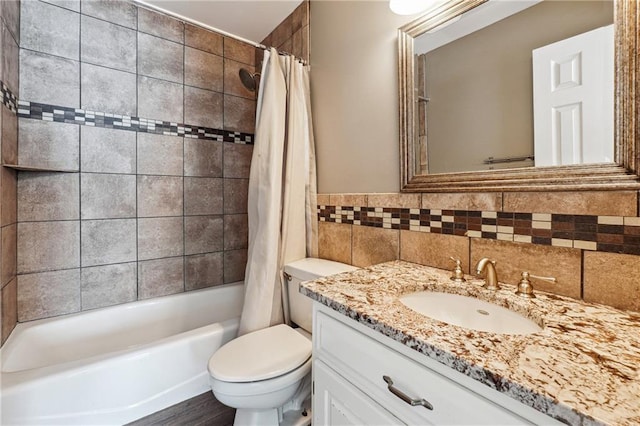 full bathroom with vanity, tile walls, toilet, and shower / bathtub combination with curtain