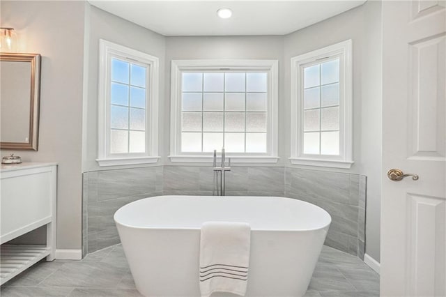 bathroom with vanity, a tub, and plenty of natural light