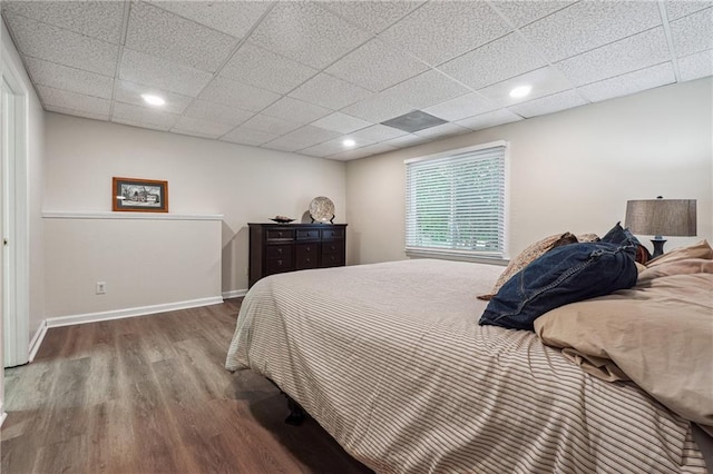 bedroom with hardwood / wood-style flooring and a paneled ceiling