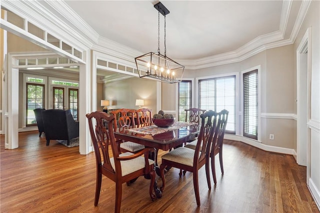 dining room with ornamental molding, an inviting chandelier, and hardwood / wood-style floors