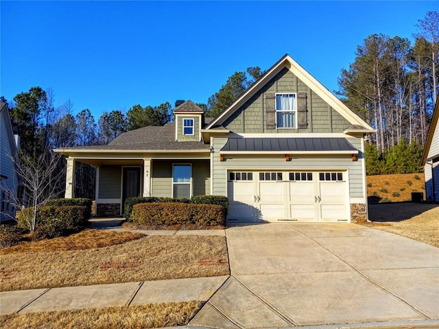 craftsman inspired home featuring stone siding, driveway, metal roof, and a standing seam roof