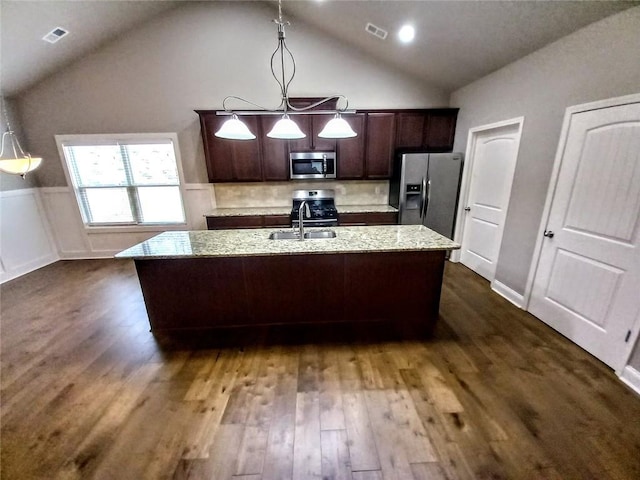 kitchen featuring visible vents, appliances with stainless steel finishes, dark wood-type flooring, and a kitchen island with sink