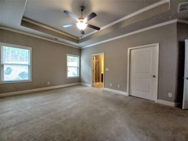 unfurnished bedroom featuring visible vents, baseboards, carpet flooring, crown molding, and a raised ceiling