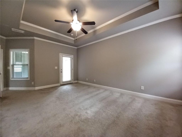 empty room featuring crown molding, baseboards, carpet floors, a raised ceiling, and a ceiling fan