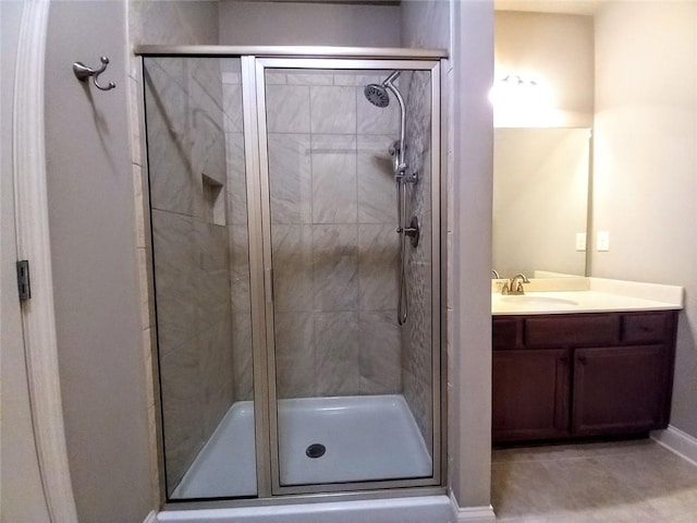 full bath with a stall shower, vanity, and baseboards