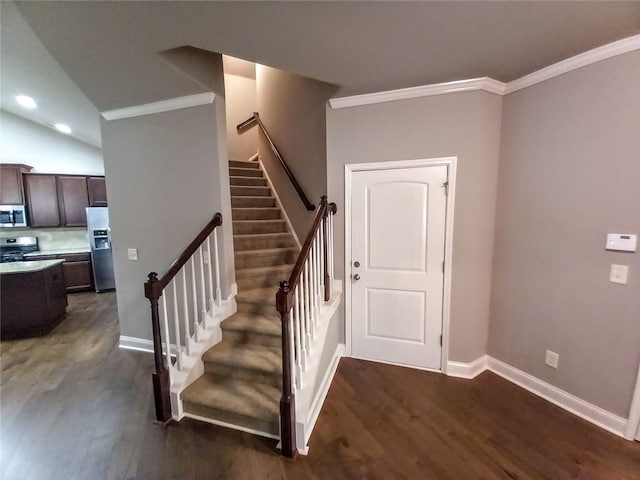 staircase with wood finished floors, baseboards, and ornamental molding