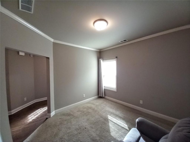 unfurnished room featuring visible vents, baseboards, carpet floors, and ornamental molding