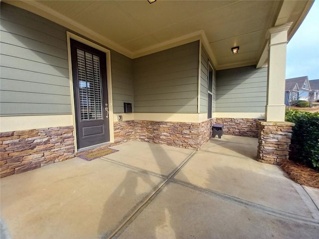 property entrance featuring a porch and stone siding