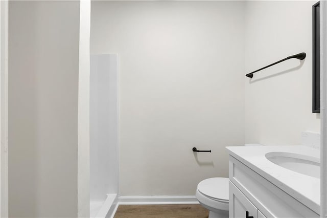 bathroom with vanity, hardwood / wood-style floors, a shower, and toilet