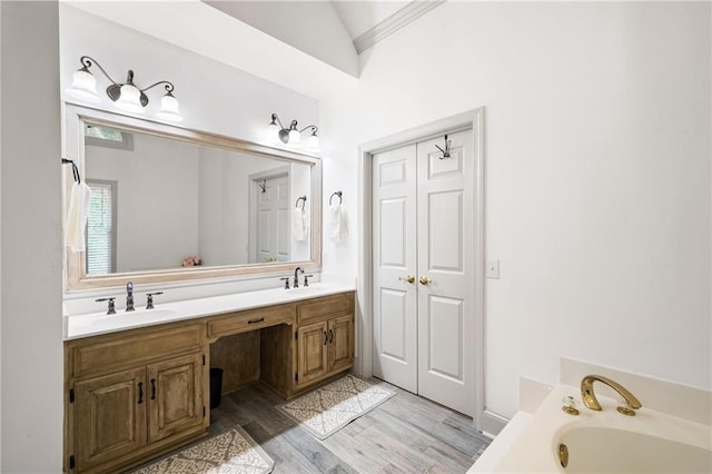 1642 Reflections Trl, Powder Springs, GA 30127 - full bathroom featuring double vanity, a garden tub, wood finished floors, and lofted ceiling