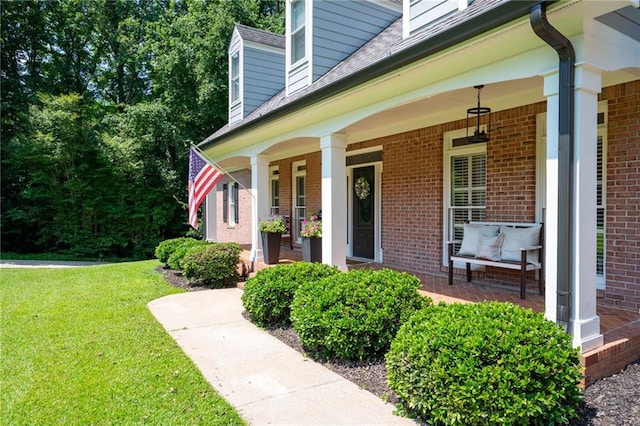 1642 Reflections Trl, Powder Springs, GA 30127 - doorway to property featuring brick siding, covered porch, a yard, and roof with shingles
