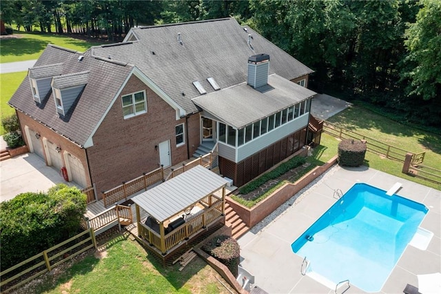 1642 Reflections Trl, Powder Springs, GA 30127 - back of property featuring a deck, a garage, a sunroom, a chimney, and roof with shingles