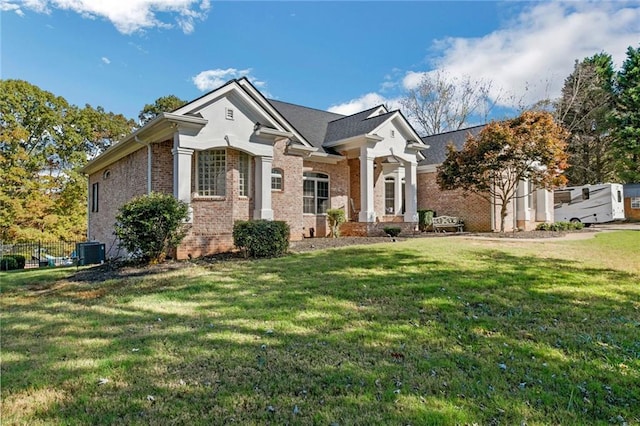 view of front of property with a front lawn and central air condition unit