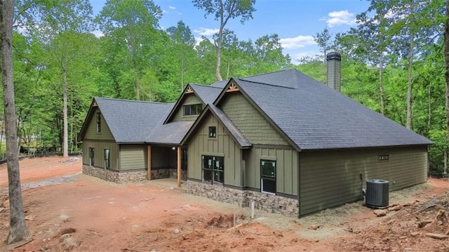 381 Chattahoochee Glen Rd, Clarkesville, GA 30523 - view of front of house with board and batten siding, central air condition unit, a chimney, roof with shingles, and stone siding