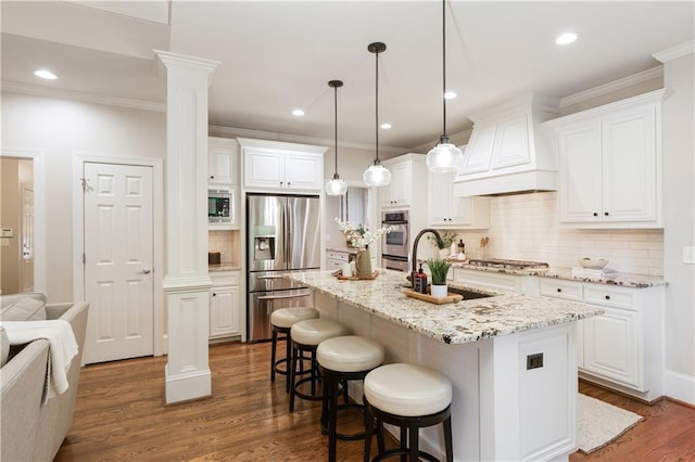kitchen with ornate columns, appliances with stainless steel finishes, decorative backsplash, and premium range hood