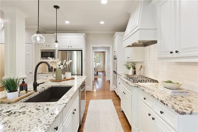 kitchen featuring dark wood-style flooring, custom exhaust hood, white cabinets, a sink, and appliances with stainless steel finishes