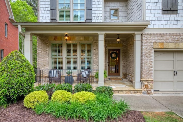 entrance to property with covered porch, concrete driveway, and brick siding