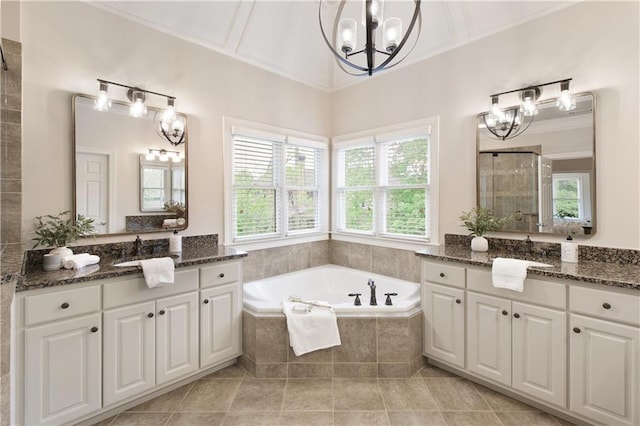 bathroom featuring a notable chandelier, a sink, a bath, and a stall shower