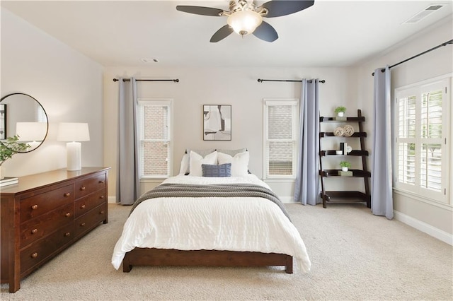 bedroom featuring baseboards, visible vents, light carpet, and ceiling fan