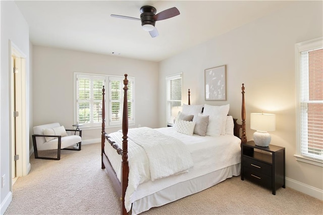 bedroom featuring baseboards, multiple windows, and light colored carpet