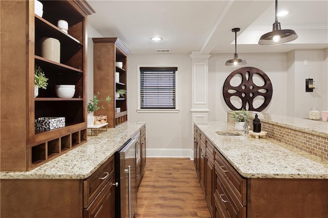 bar with beverage cooler, baseboards, wood finished floors, visible vents, and pendant lighting