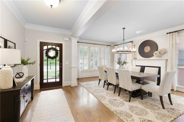 dining space featuring crown molding, baseboards, a chandelier, and light wood-type flooring