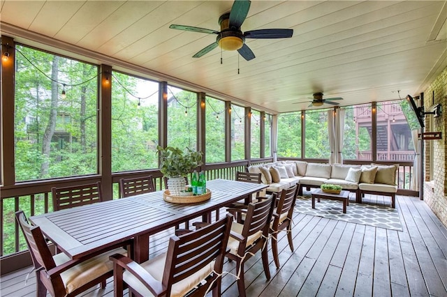 sunroom / solarium with a ceiling fan, outdoor dining space, and an outdoor living space