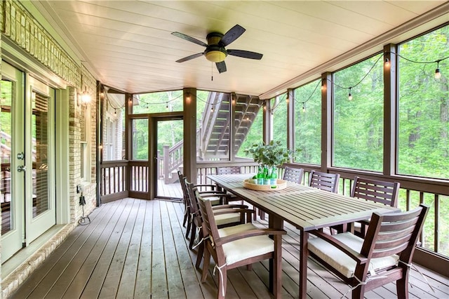 sunroom / solarium featuring outdoor dining area and a ceiling fan
