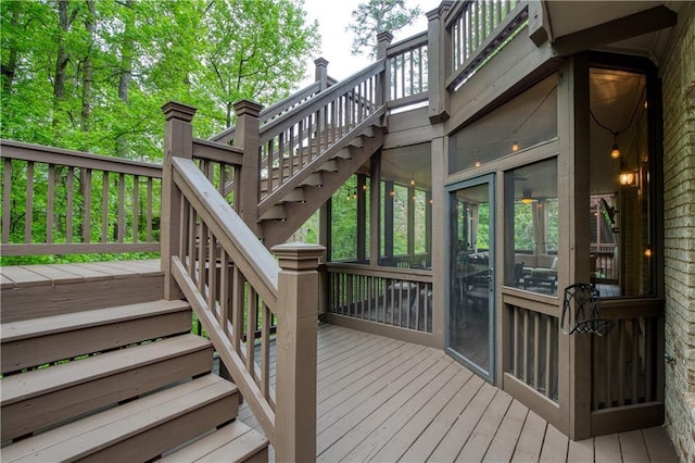 wooden deck with stairs and a sunroom