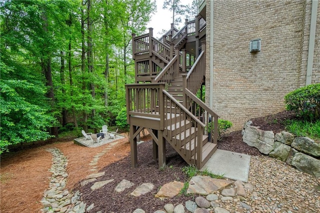 view of yard featuring stairway, a deck, a patio, and an outdoor fire pit