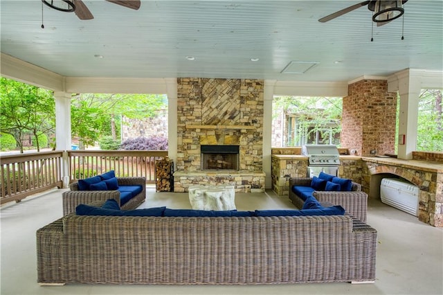 view of patio / terrace featuring ceiling fan, an outdoor living space with a fireplace, a grill, and an outdoor kitchen