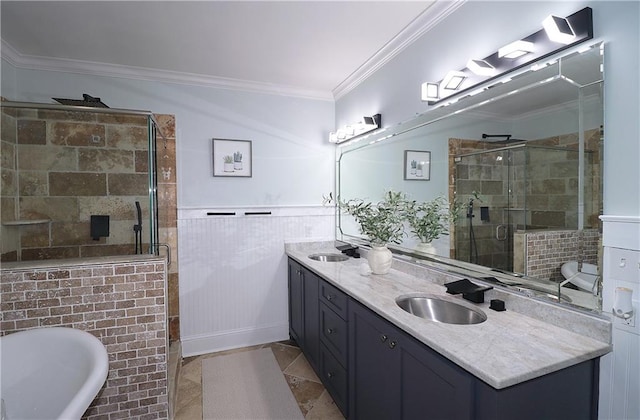 full bath with a sink, a wainscoted wall, a freestanding bath, and crown molding