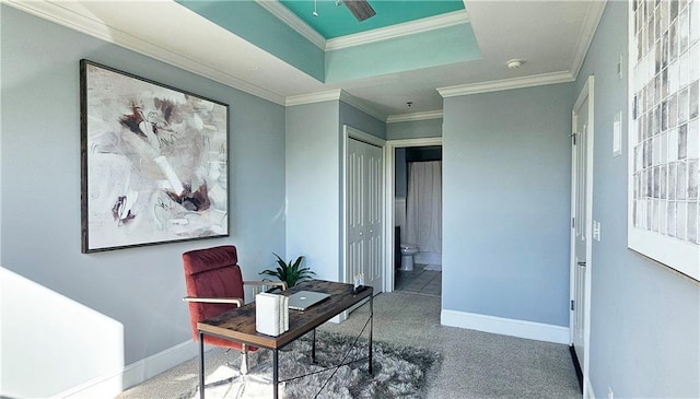office space with ornamental molding, carpet floors, baseboards, and a tray ceiling