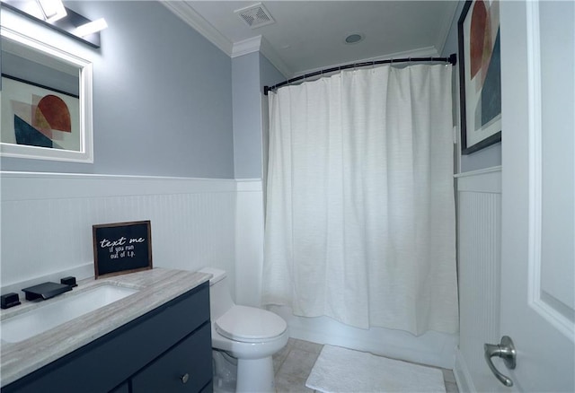 full bath featuring vanity, ornamental molding, visible vents, a wainscoted wall, and toilet
