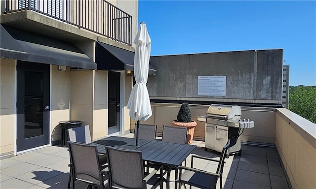 view of patio / terrace with a grill, outdoor dining space, and a balcony