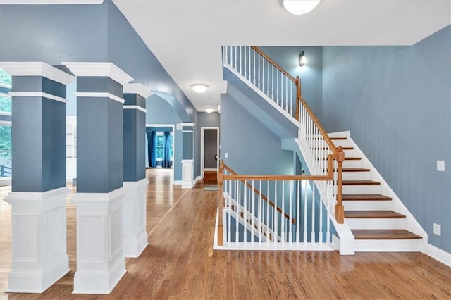 212 Thorncliff Way, Acworth, GA 30101 - stairs with wood finished floors, arched walkways, ornate columns, and high vaulted ceiling