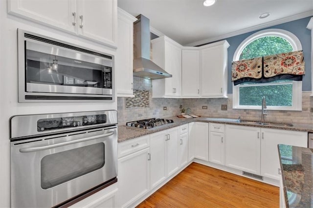 212 Thorncliff Way, Acworth, GA 30101 - kitchen with stainless steel appliances, wall chimney range hood, dark stone countertops, recessed lighting, and ornamental molding