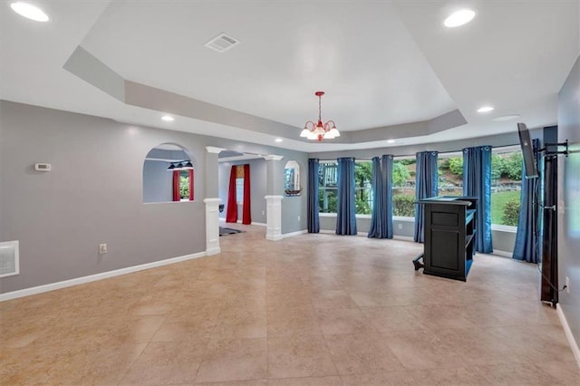 212 Thorncliff Way, Acworth, GA 30101 - unfurnished living room with ornate columns, a tray ceiling, recessed lighting, and a chandelier