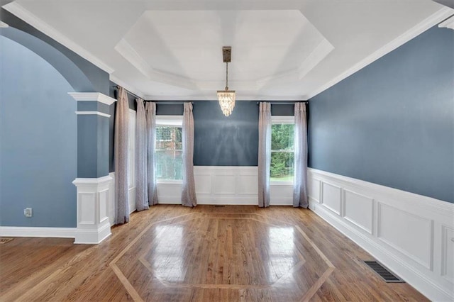212 Thorncliff Way, Acworth, GA 30101 - unfurnished dining area with healthy amount of natural light, arched walkways, a raised ceiling, wood finished floors, and a wainscoted wall