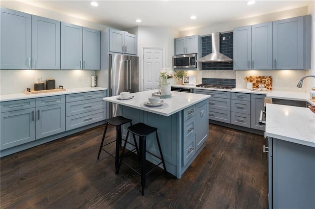 5828 Paliser Trce, Sugar Hill, GA 30518 - kitchen featuring appliances with stainless steel finishes, wall chimney exhaust hood, a kitchen breakfast bar, a sink, and a kitchen island