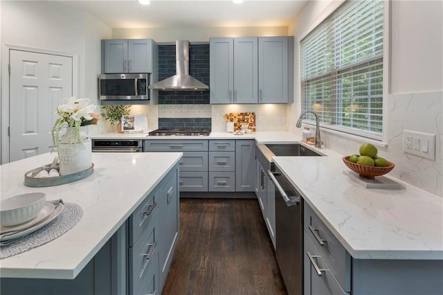 5828 Paliser Trce, Sugar Hill, GA 30518 - kitchen with wall chimney range hood, appliances with stainless steel finishes, a sink, gray cabinetry, and dark wood-style flooring