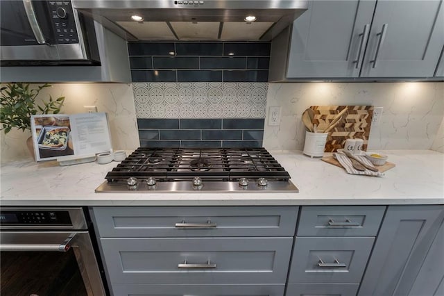 5828 Paliser Trce, Sugar Hill, GA 30518 - kitchen featuring gray cabinets, stainless steel appliances, backsplash, under cabinet range hood, and light stone countertops