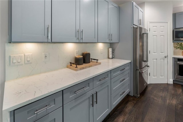 5828 Paliser Trce, Sugar Hill, GA 30518 - kitchen with appliances with stainless steel finishes, gray cabinets, dark wood-style floors, light stone counters, and backsplash