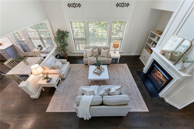 5828 Paliser Trce, Sugar Hill, GA 30518 - living room featuring dark wood-style flooring, baseboards, a fireplace with flush hearth, and a towering ceiling