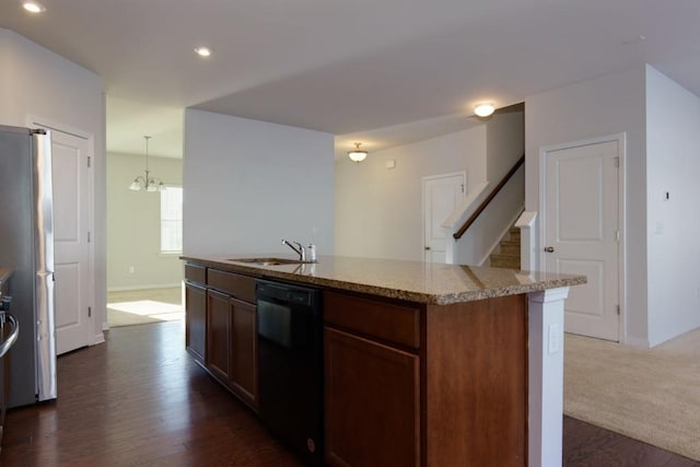 kitchen with an island with sink, stainless steel fridge, sink, black dishwasher, and decorative light fixtures