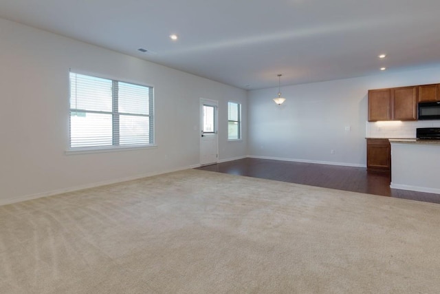 unfurnished living room with dark carpet