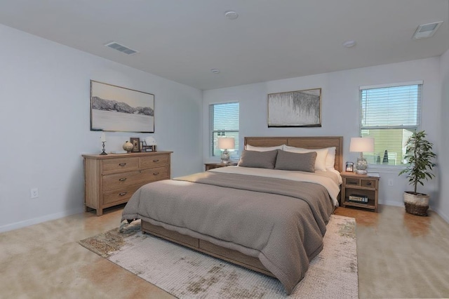 bedroom featuring light colored carpet and multiple windows