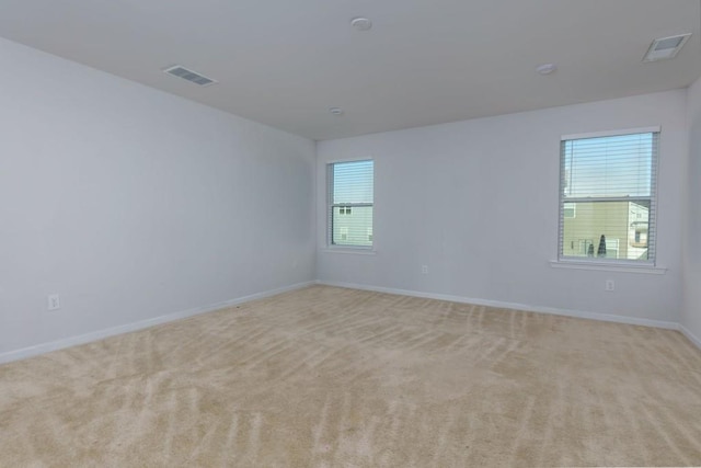 spare room featuring light colored carpet