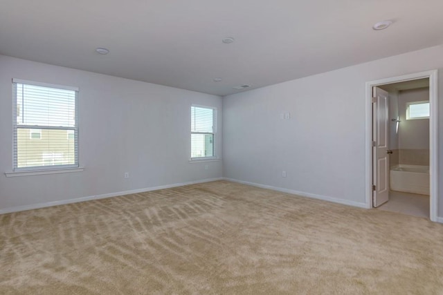 empty room with a wealth of natural light and light colored carpet