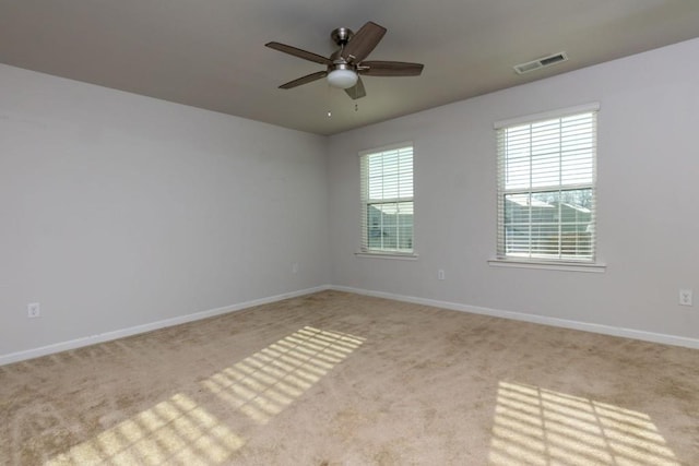 carpeted spare room featuring ceiling fan